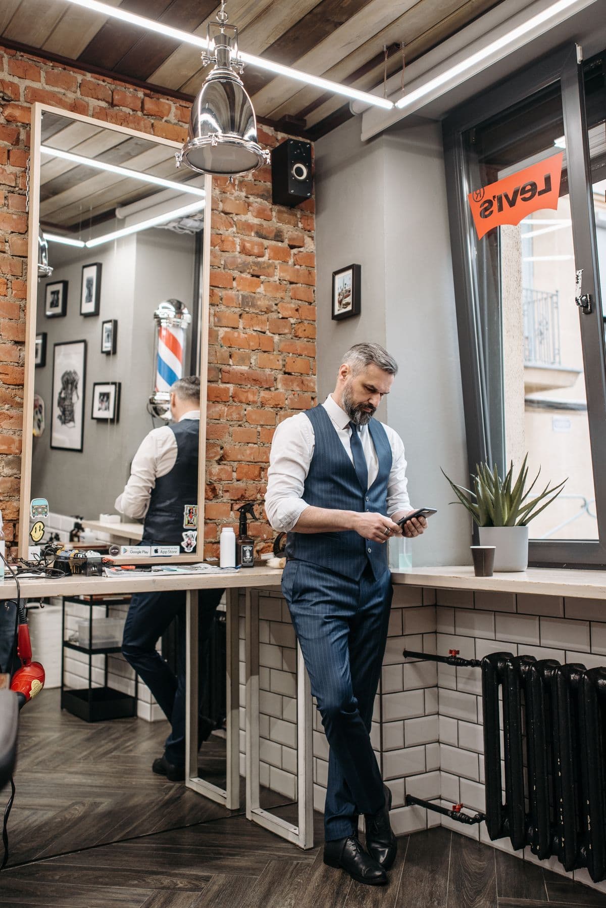 Professionnel consultant son téléphone dans un salon de coiffure