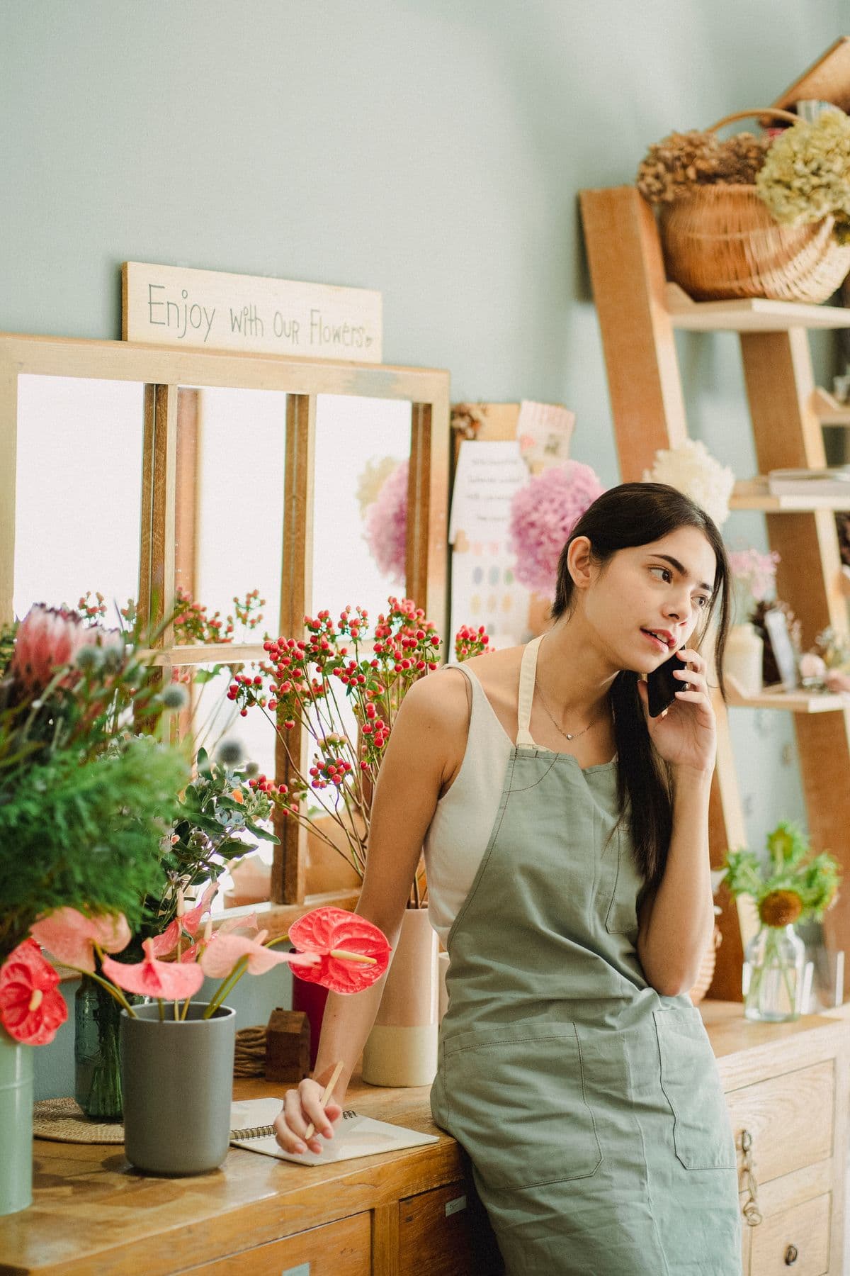 Commerçante au téléphone dans une boutique de fleurs